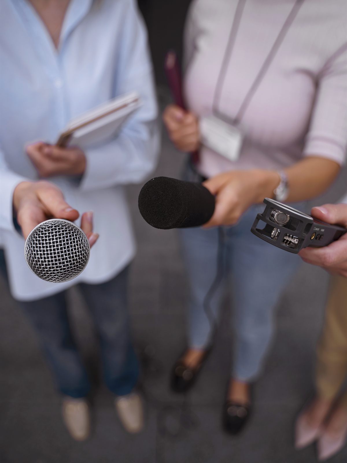 Periodistas siguiendo una pauta con micrófonos y grabadora